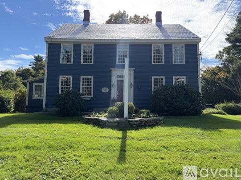A blue house with a white door and windows.