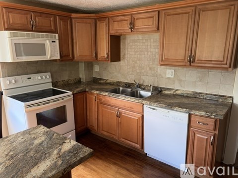 A kitchen with wooden cabinets and a granite countertop.