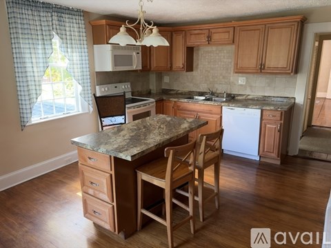 A kitchen with wooden cabinets and a granite countertop.