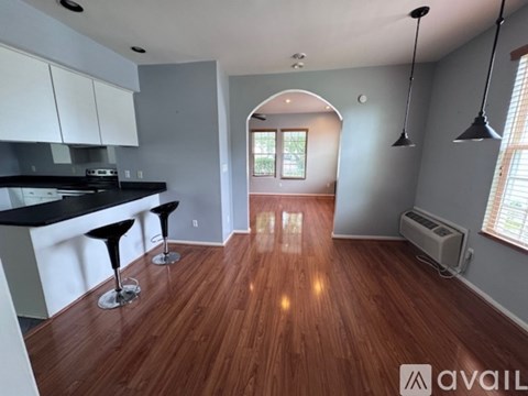 A kitchen with a bar and two stools.