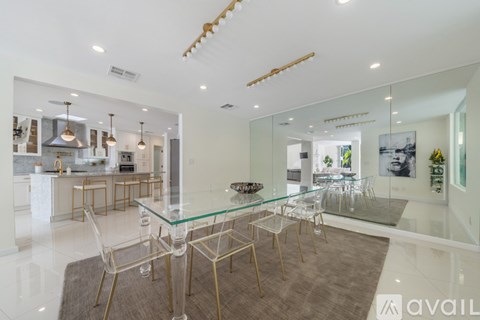 A modern kitchen with a glass table and chairs.