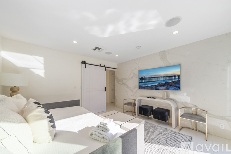 A modern bedroom with a large bed and a painting on the wall.
