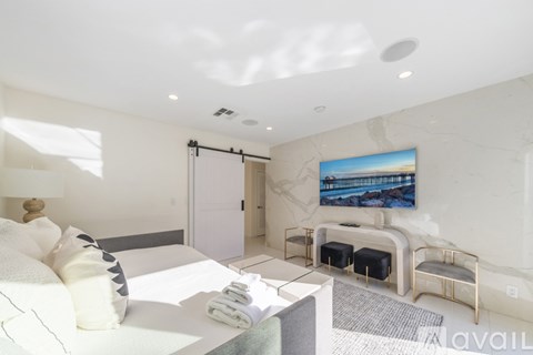 A modern bedroom with a large bed and a painting on the wall.