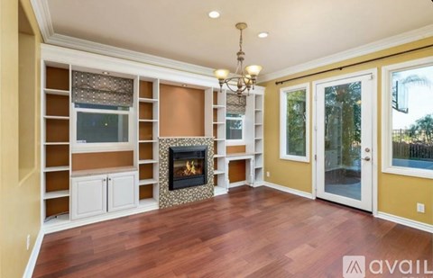 A living room with a fireplace and a chandelier.