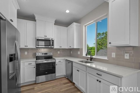 A kitchen with white cabinets and stainless steel appliances.