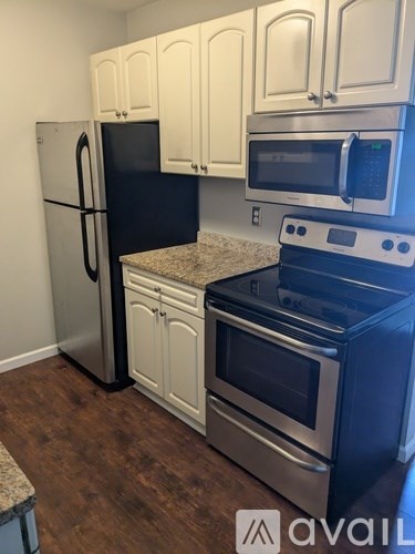 A kitchen with a stainless steel refrigerator, microwave, and oven.