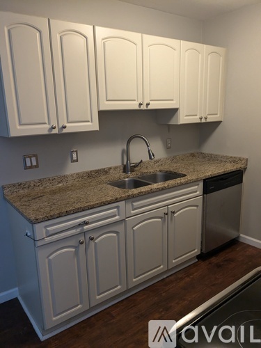 A kitchen with white cabinets and a granite countertop.