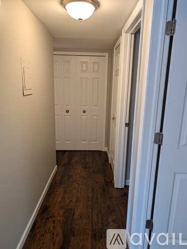 A hallway with a white door and a light on the ceiling.