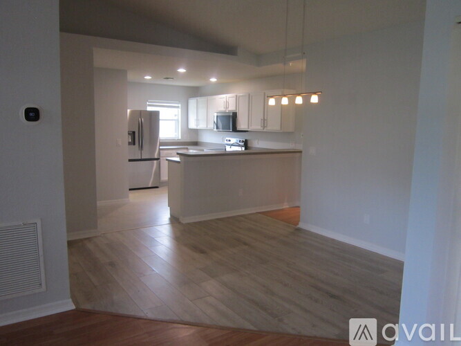 A kitchen with a refrigerator, microwave, and oven is available for rent.