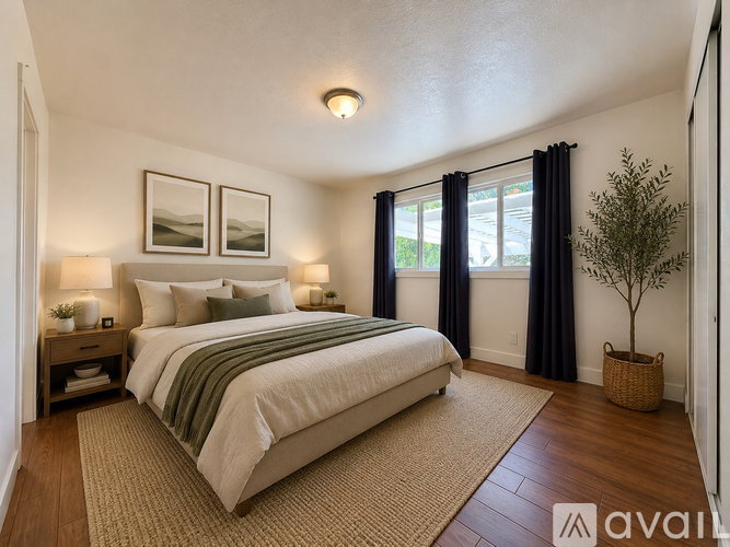 A bedroom with a large bed and a plant.