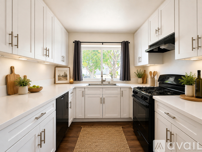 A kitchen with white cabinets and black appliances.