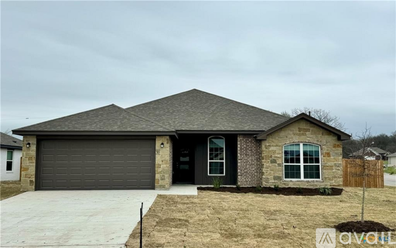 A house with a grey garage door and a brown fence.