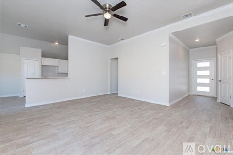 A spacious room with a ceiling fan and lighting fixtures.