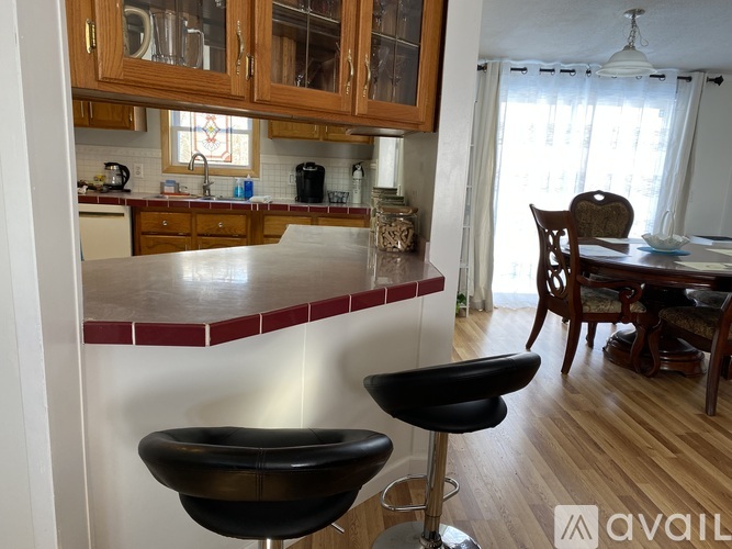 A kitchen with a bar stool in front of it.