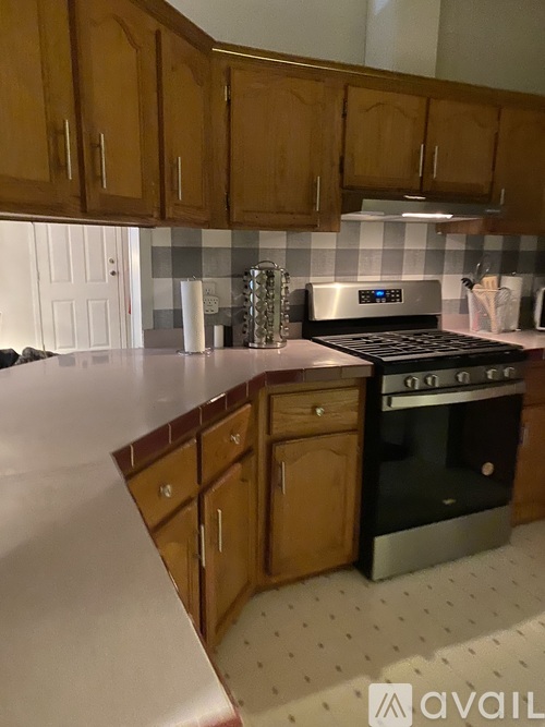 A kitchen with wooden cabinets and a black stove top oven.