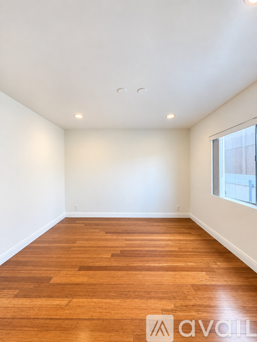 A room with wooden flooring and a window.