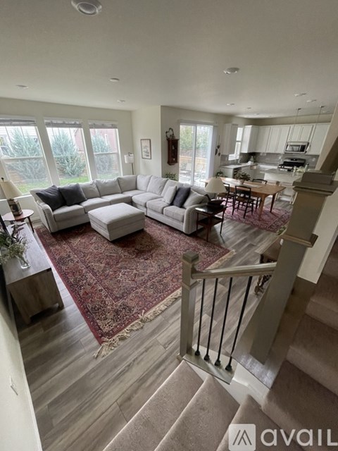 A living room with a couch, chairs, and a rug.