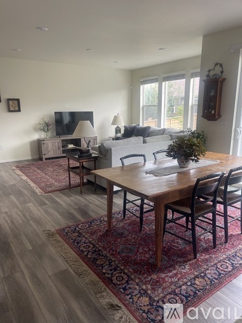 A living room with a wooden table and chairs.