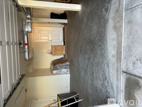 A small, narrow kitchen with a white cabinet and a black stove top oven.