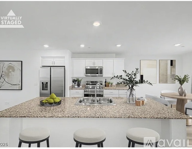 A modern kitchen with a granite countertop and white cabinets.