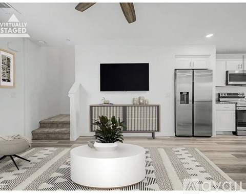 A modern living room with a flat screen TV mounted on the wall.