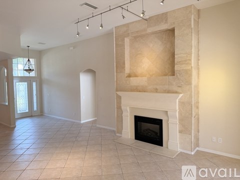 A living room with a fireplace and a tiled floor.