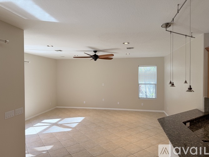 A spacious room with a ceiling fan and a window.