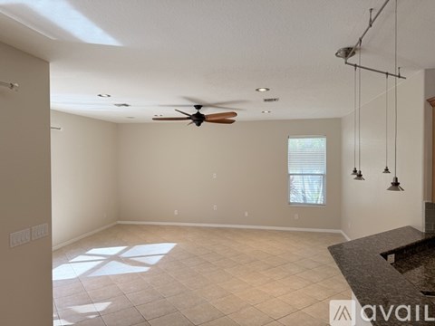 A spacious room with a ceiling fan and a window.