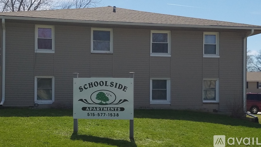 A sign for Schoolside Apartments is in front of a building.
