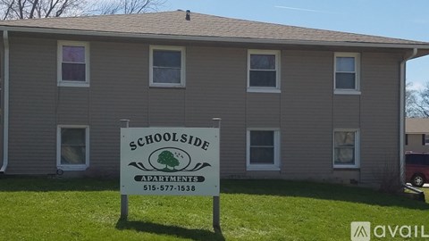 A sign for Schoolside Apartments is in front of a building.
