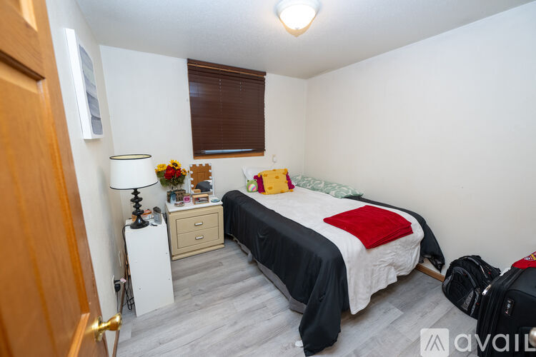 A bedroom with a bed, nightstand, and a lamp.
