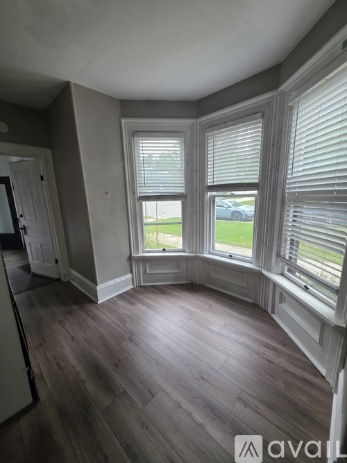A room with a window and wooden floors.