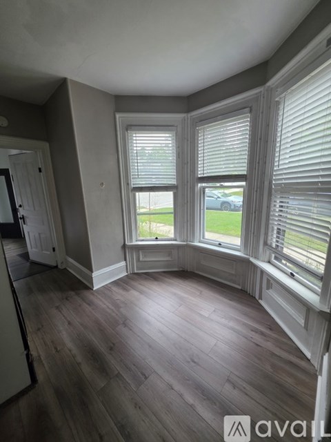 A room with a window and wooden floors.