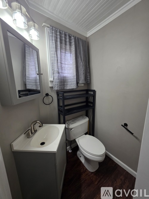 A small bathroom with a toilet, sink, and a mirror.