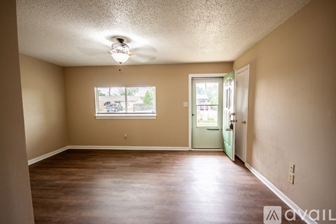 A room with a ceiling fan and a window with blinds.