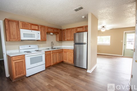 A kitchen with wooden cabinets and white appliances.