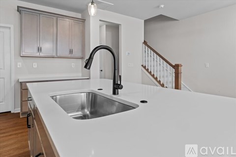 A modern kitchen with a stainless steel sink and a black faucet.