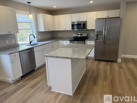 A kitchen with white cabinets and a granite countertop.