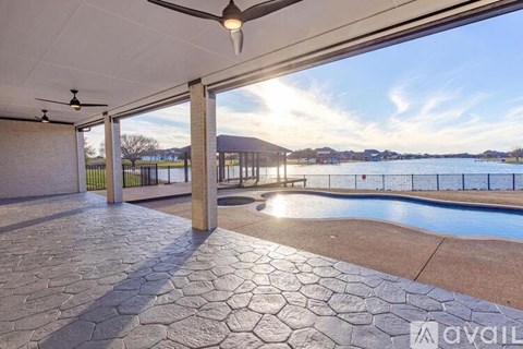 A patio with a pool and a ceiling fan.