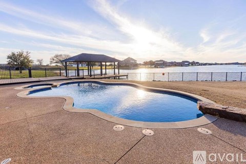 A swimming pool with a pavilion in the background.