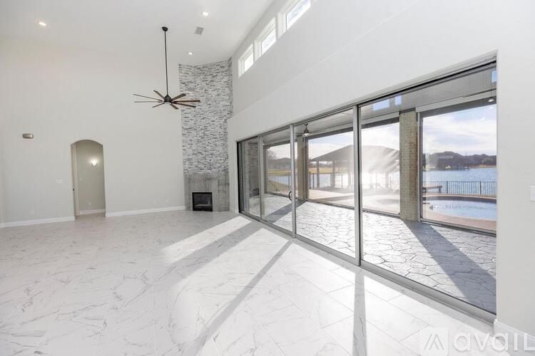 A spacious room with a marble floor and a ceiling fan.