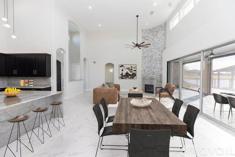 A modern dining room with a wooden table and black chairs.
