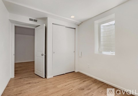 A room with a white door and a window with blinds.