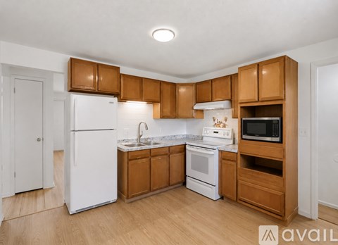 A kitchen with wooden cabinets and white appliances.