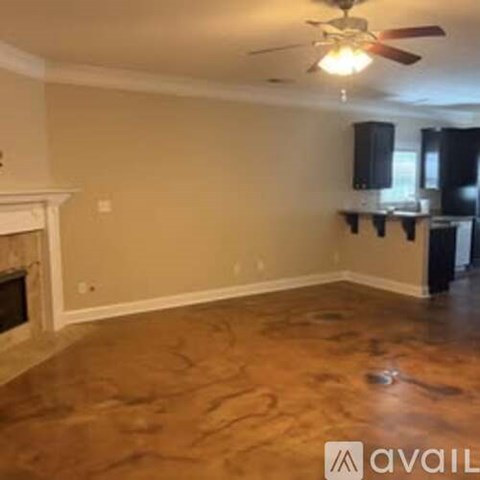 A living room with a fireplace and a ceiling fan.
