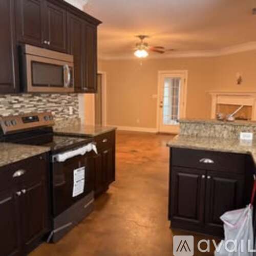 A kitchen with dark brown cabinets and a stone backsplash.