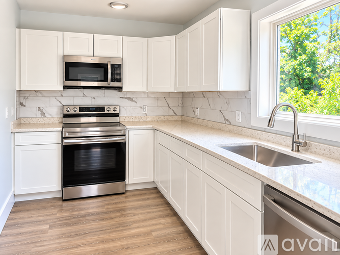 A kitchen with white cabinets and a stainless steel oven.