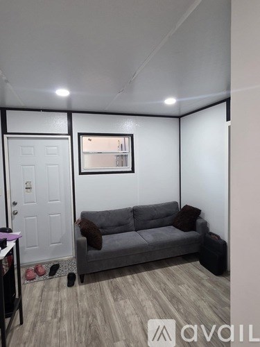 A living room with a grey couch and a white door.