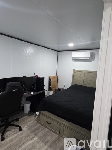 A bedroom with a bed, desk, and chair.