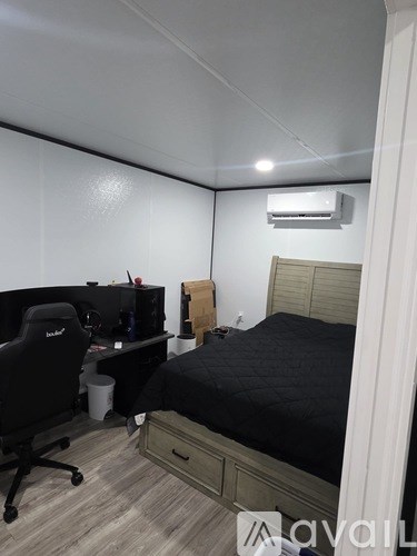 A bedroom with a bed, desk, and chair.